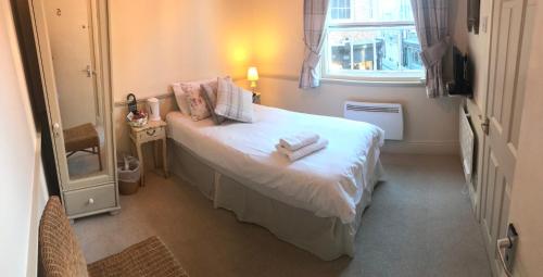 a small bedroom with a bed with towels on it at Galtres Lodge Hotel & Forest Restaurant in York