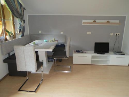 a living room with a table and a desk with a computer at Ascherhof in Auffach