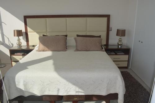 1 dormitorio con 1 cama grande y 2 mesitas de noche en Costa Puyai - Exclusivo Departamento en primera línea- Playa Punta Puyai, en Papudo