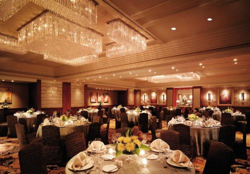 a banquet hall with tables and chairs and chandeliers at Makati Shangri-La, Manila in Manila