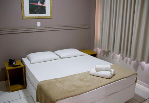Un pat sau paturi într-o cameră la Presidente Hotel
