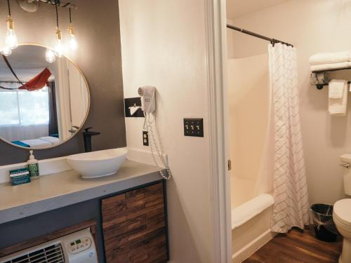 a bathroom with a sink and a toilet and a mirror at LOGE Bend in Bend