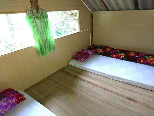 2 camas en una habitación pequeña con ventana en Dzay house homestay, en Sa Pa