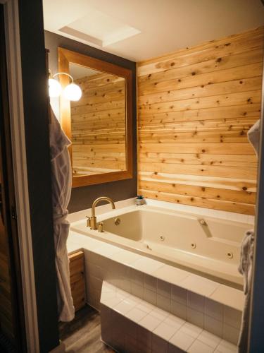 a bathroom with a tub and a wooden wall at LOGE Bend in Bend