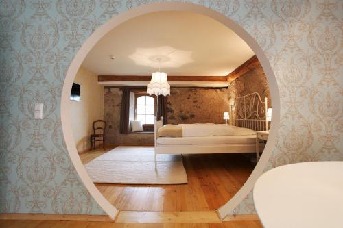 a bedroom with a bed through an archway at hotel rainhof scheune & naturpark restaurant (Kirchzarten) in Kirchzarten