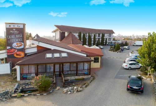 a building with a car parked in a parking lot at Motel Dacia in Sebeş