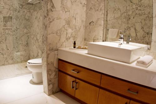 a bathroom with a sink and a toilet at Pennsylvania Suites in Mexico City