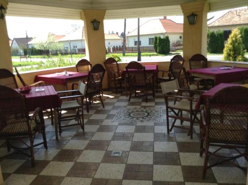 レンティにあるFőnix Fogadóの紫色のテーブルと椅子が備わるパティオ付きのレストラン