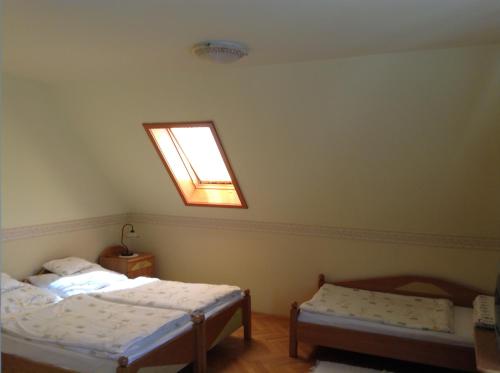 a bedroom with two beds and a window at Főnix Fogadó in Lenti