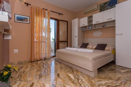 sypialnia z łóżkiem i dużym oknem w obiekcie Apartments Verica - 15 m from beach w mieście Krilo