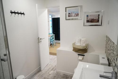 a white bathroom with a sink and a mirror at Alfama Secret - Cozy&Sweet in Lisbon