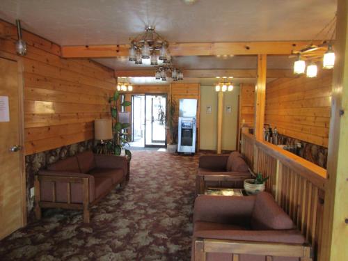 a living room with couches and tables in a building at Captain's Choice Motel in Haines