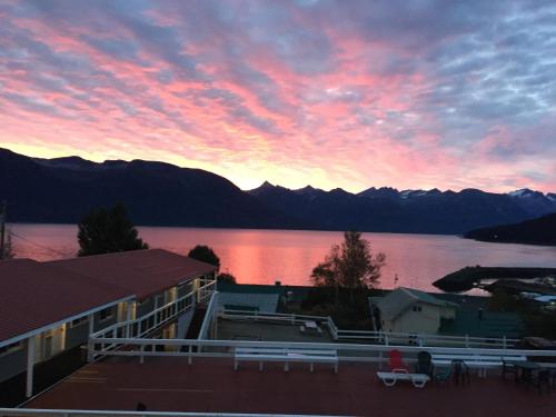 a view of a sunset over a lake with mountains at Captain's Choice Motel in Haines