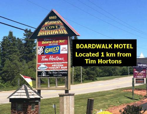 a sign for a boardwalk motel on the side of a road at Boardwalk Motel in Cavendish