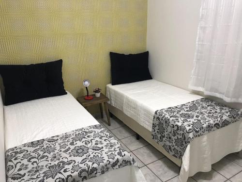 フォス・ド・イグアスにあるMorada Felizのベッド2台が隣同士に設置された部屋です。