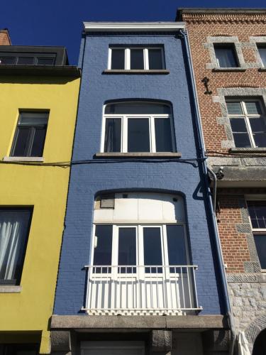 a blue building with a white window at Les Voisins De Mr Sax in Dinant