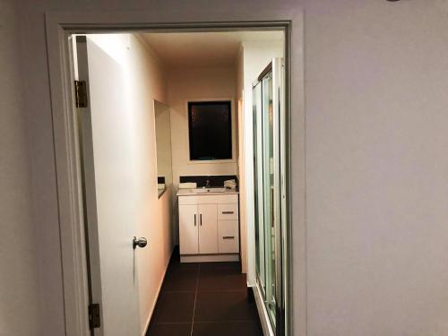 a hallway with a door open to a kitchen at Grosvenor Motel in Hamilton