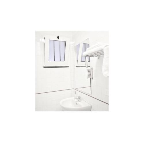 biała łazienka z umywalką i lustrem w obiekcie Secret Room Naples w mieście Neapol
