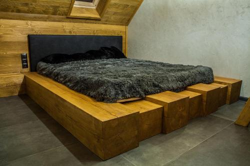 sypialnia z łóżkiem z drewnianą platformą w obiekcie Apartament Mountain Chalet w mieście Szczawnica