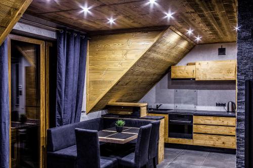 シュツァブニツァにあるApartament Mountain Chaletの木製の天井、テーブルと椅子付きのキッチンが備わります。