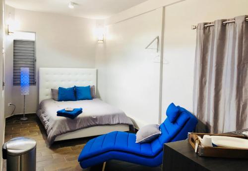 a bedroom with a bed and a blue chair at Modern Suite #0 - best location in Aguadilla