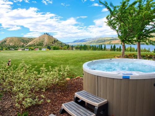a jacuzzi tub with a bench in a field at Mt Michael Lodge in Cromwell