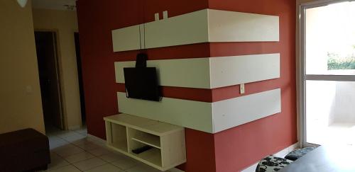 a room with a wall with a tv on it at apartamento em bertioga in Bertioga