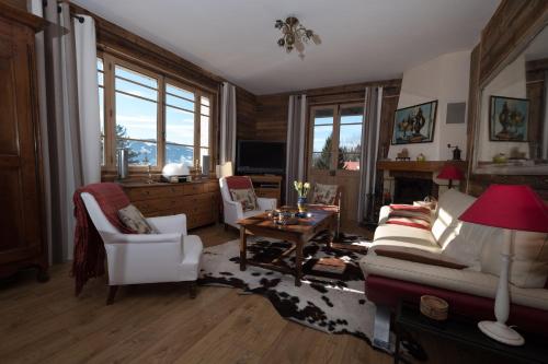 a living room with a couch and chairs and a table at CHALET Les Chouchous in Passy