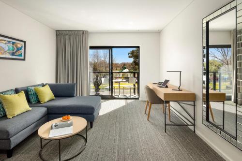 a living room with a couch and a table at Quality Hotel Lakeside in Bendigo
