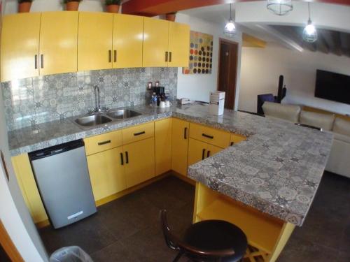 a kitchen with yellow cabinets and a counter top at Baja Inn Hoteles Rio in Tijuana