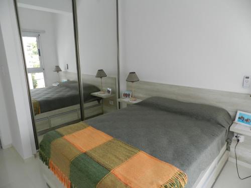 a bedroom with a bed and a large mirror at El Departamento de los Abuelos in Posadas