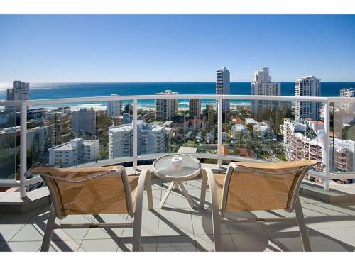 two chairs and a table on a balcony with a view at Oaks Hotel Deluxe Private Apartment and Studio - Ocean Views in Gold Coast