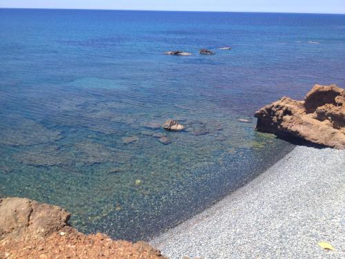a beach with rocks and the clear water at Kanalli Apartments in Pomos