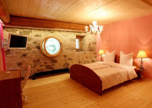 a bedroom with a large bed and a round window at hotel rainhof scheune & naturpark restaurant (Kirchzarten) in Kirchzarten