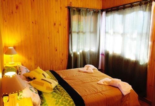 Schlafzimmer mit einem Bett und einem Fenster in der Unterkunft Cabanas Inti-Wari Jujuy in El Ceibal