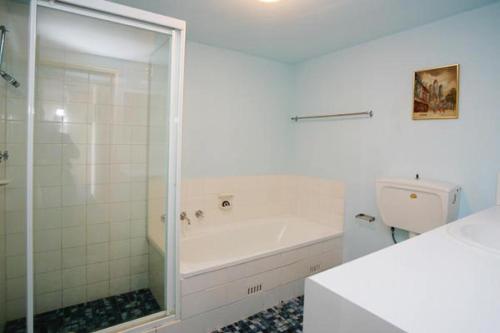 Un baño blanco con bañera y inodoro. en Ebbtide Unit 33, en Forster