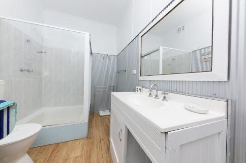 a bathroom with a sink and a toilet and a shower at DOUGLAS COTTAGE FORSTER in Forster
