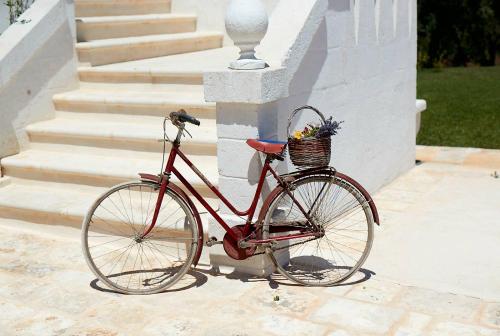 Una bicicleta con una cesta estacionada junto a unas escaleras en Masseria Almadava en Polignano a Mare