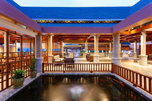 - une piscine au milieu d'une maison avec une terrasse couverte dans l'établissement Orchidacea Resort - Kata Beach, à Kata Beach
