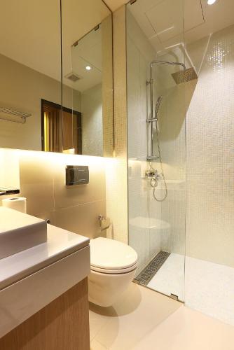 a bathroom with a toilet and a glass shower at Montana Hotel Songkhla in Songkhla