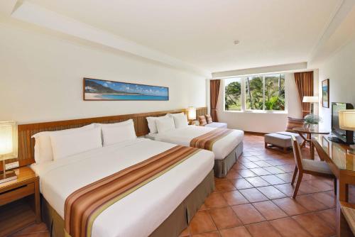 a hotel room with two beds and a television at Fullon Resort Kending in Eluan