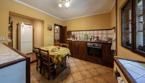 a kitchen with a table and a white refrigerator at Toscana Villa in Snagov