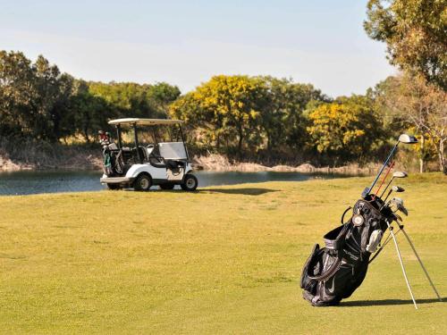 a golf cart parked on a field next to a golf ball at Le Médina Essaouira Thalassa Sea & Spa - MGallery Collection in Essaouira