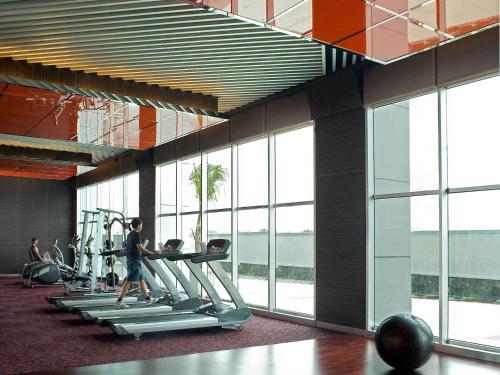 a gym with people exercising on treadmills in a building at Novotel Bangka Hotel & Convention Center in Pangkalpinang