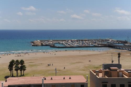 a group of people on a beach near the ocean at Hotel Natura Park in Comarruga
