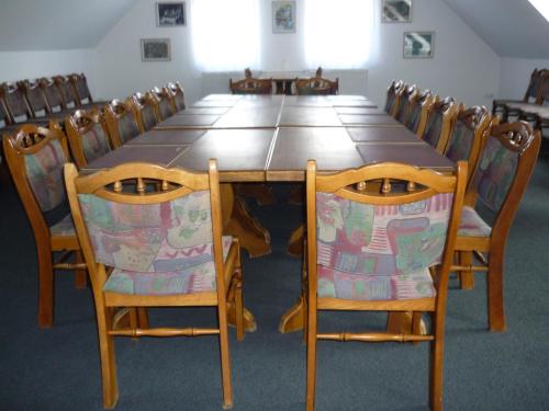 a long wooden table with chairs around it at Öreg Malom Hotel in Csepreg