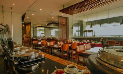 un ristorante con sala da pranzo con tavoli e sedie di PrimeBiz Hotel Surabaya a Surabaya