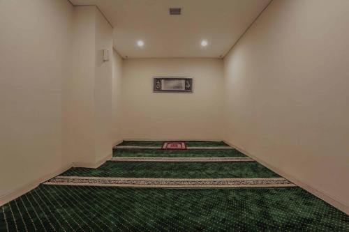 an empty room with a green rug on the floor at PrimeBiz Hotel Surabaya in Surabaya