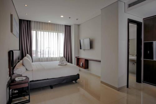 a bedroom with a bed and a large window at PrimeBiz Hotel Surabaya in Surabaya