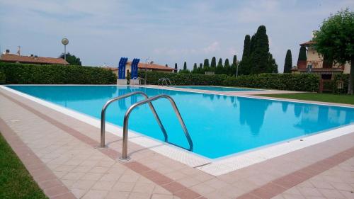 ein Swimmingpool mit blauem Wasser in einem Hof in der Unterkunft Sole di Lazise in Lazise